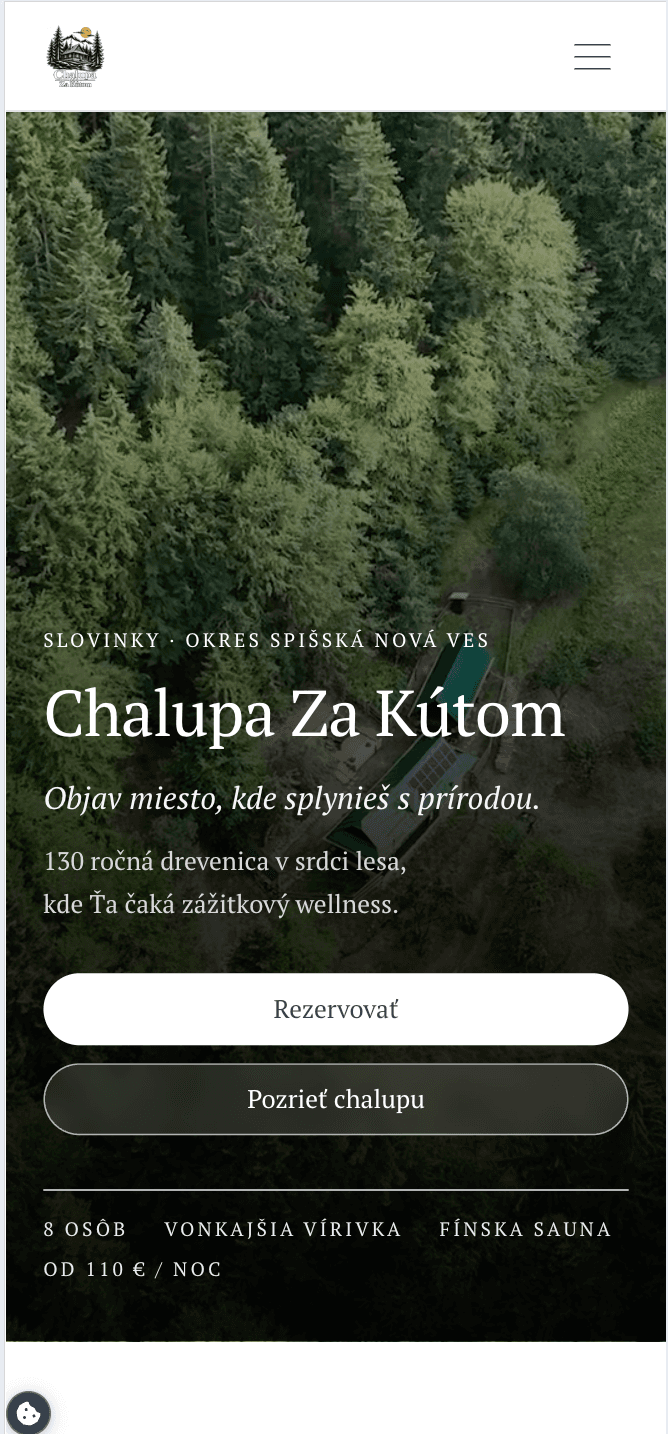 Úvodní obrazovka webu Chalupa Za Kútom na mobilu s leteckým záběrem lesa.